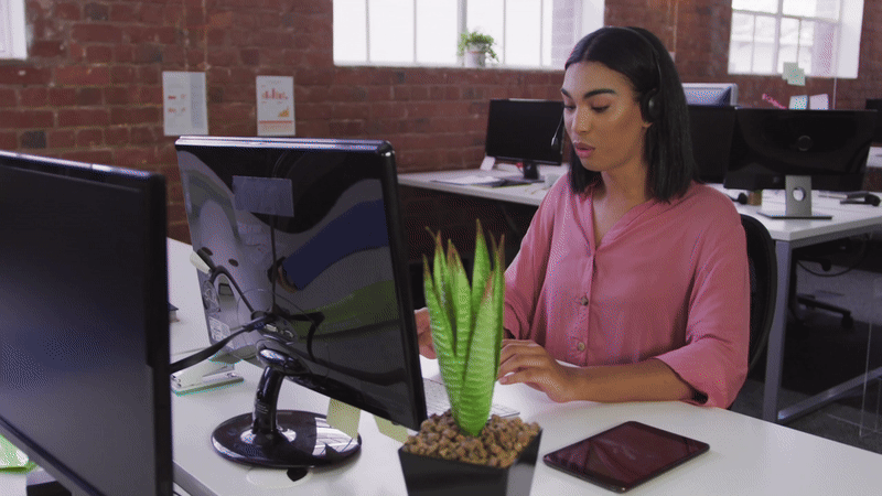 Person working at a desk with plants.